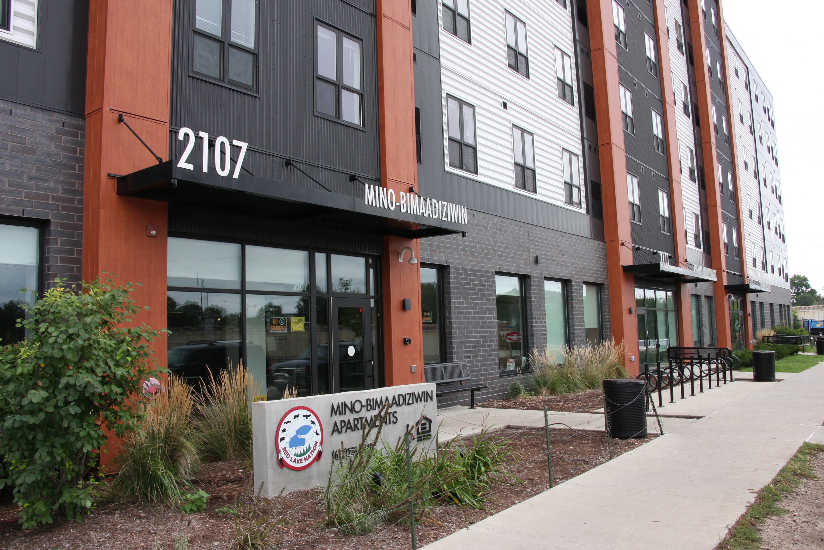 a building with a sidewalk and a sign in front of it